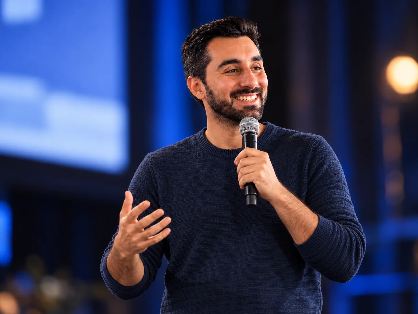 Renan de Paula com um microfone, falando em um evento
